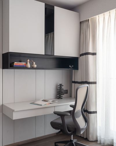 Built-in study nook with floating desk, mesh chair, and sheer curtained window