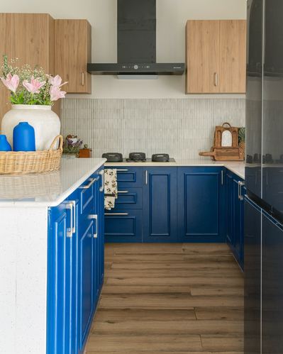 L-shaped kitchen with navy blue cabinetry, wooden upper cabinets, and ribbed tile backsplash