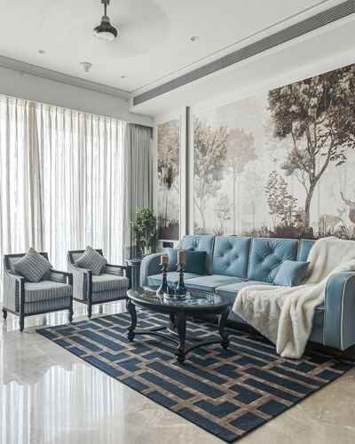 Living room with blue tufted sectional, striped armchairs, and forest mural on marble flooring