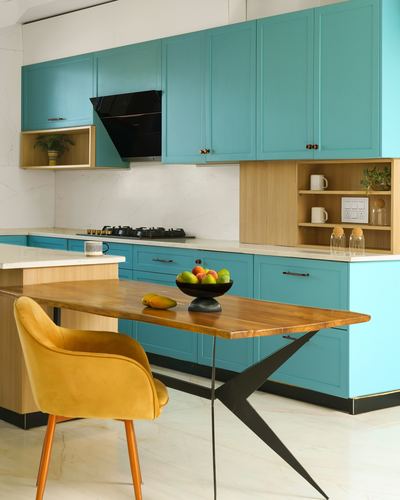 Turquoise modular kitchen with wooden island table and mustard velvet chair