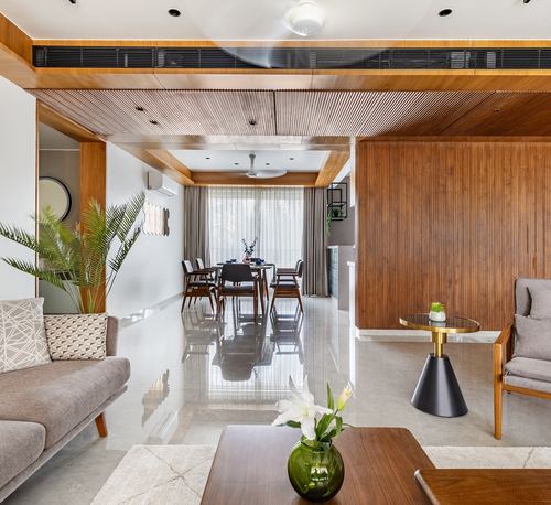 Living and dining space with ribbed wood ceiling, wood-panel wall, and polished stone floor