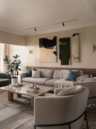 Beige living room with grey sofa, curved chairs, stone coffee table and green-toned triptych art