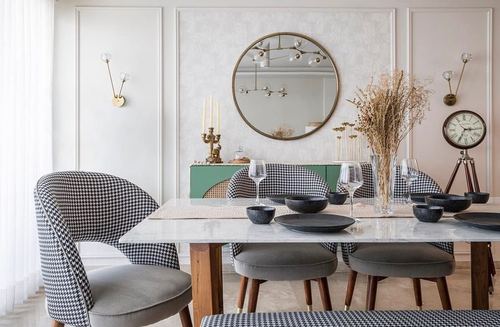 Dining table with houndstooth chairs, marble top, round mirror and sage console behind