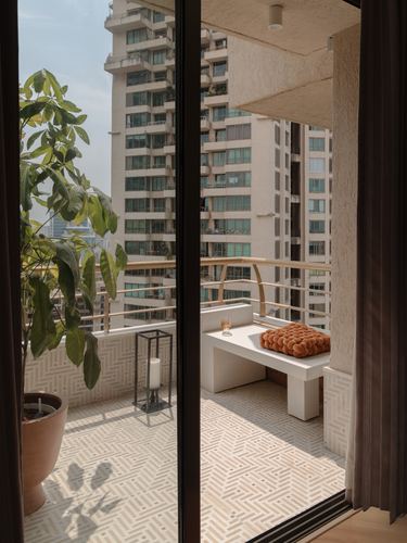 View through sliding glass doors onto a balcony with patterned tile floor and city skyline