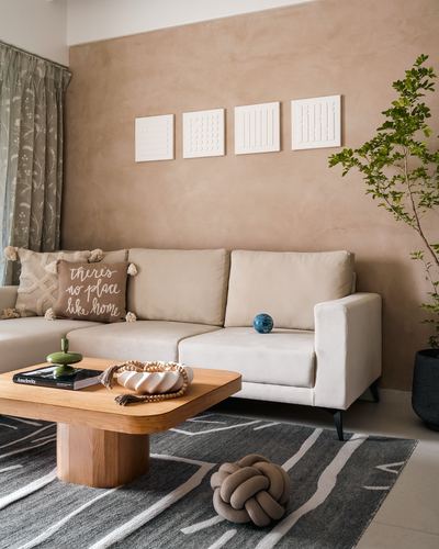 Beige sofa against a warm plaster wall with white textured art panels and a wooden coffee table