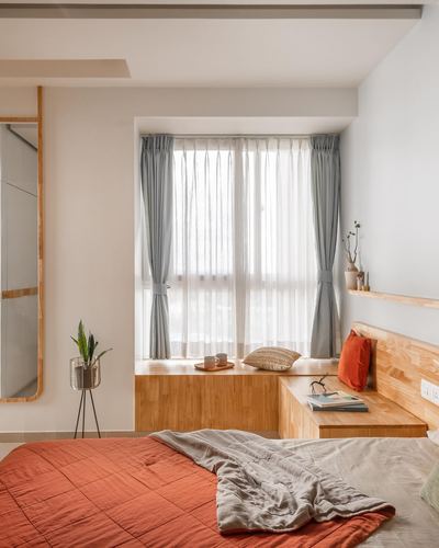 Bedroom with window seat, sheer curtains, terracotta bedding, and floor mirror