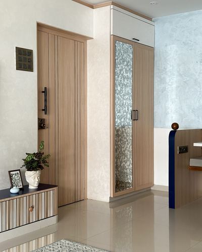 Entry foyer with fluted wood door, textured mirror wardrobe, and ribbed console table