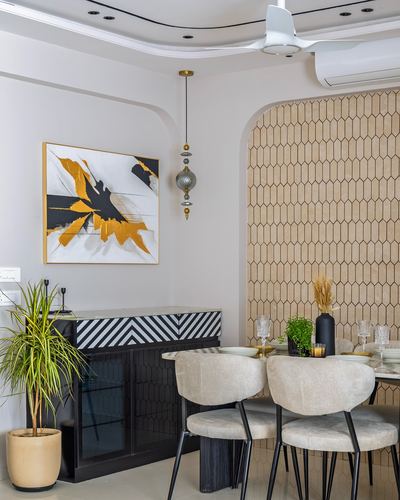 Dining nook with arched textured tile wall, black striped sideboard, and abstract gold painting
