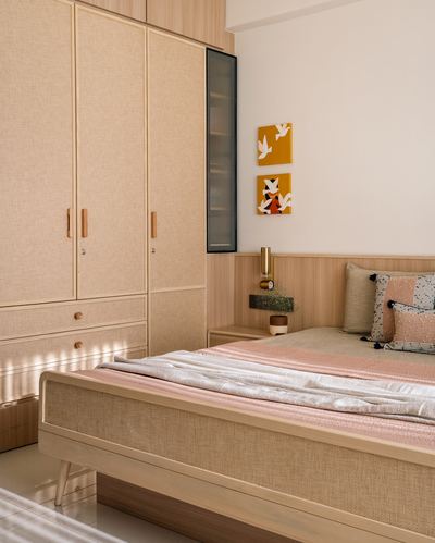 Bedroom with cane-textured wardrobe, wood-panel headboard, and mustard bird artwork