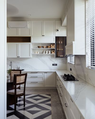 White L-shaped kitchen with veined stone backsplash, open shelving, and a geometric black-white tile floor