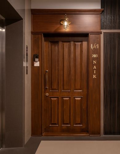 Panelled wooden entrance door with brass lantern above and nameplate reading 203 Naik