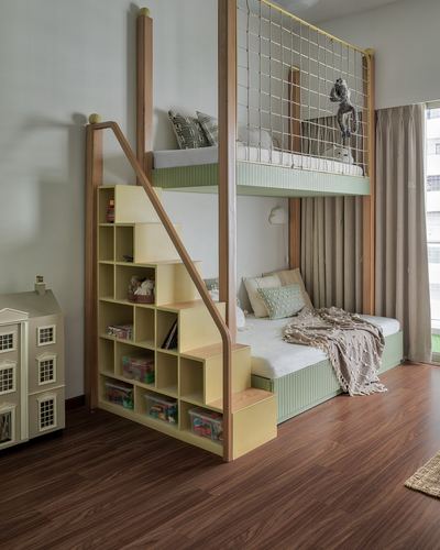 Kids bunk bed with net enclosure above, storage staircase, and dollhouse on wood floor