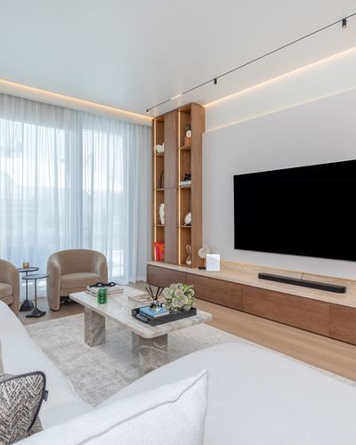 Contemporary living room with wood shelving, floating tv unit, and stone coffee table beside sheer curtained window