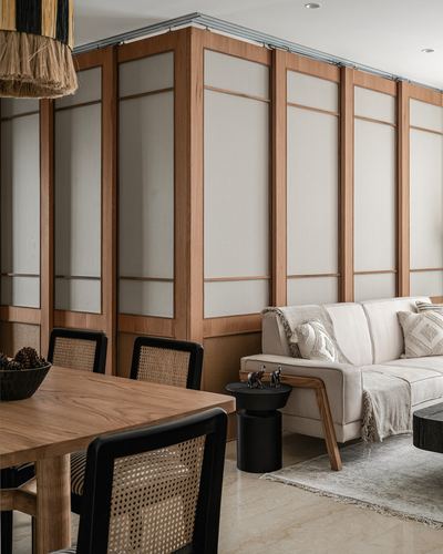 Living-dining space with wood-framed translucent sliding panels, cane chairs, and cream sofa