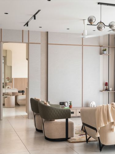 Neutral living room with olive quilted swivel chairs and sculptural globe pendant light