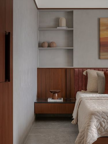 Bedroom corner with plaster niche shelving, wood panelling, floating nightstand and rust velvet headboard