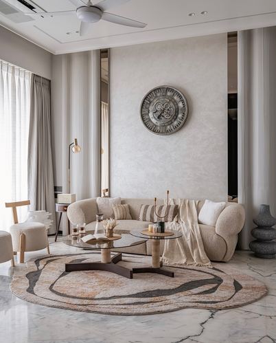 Beige curved sofa and round rug in a marble-floored living room with an oversized gear clock