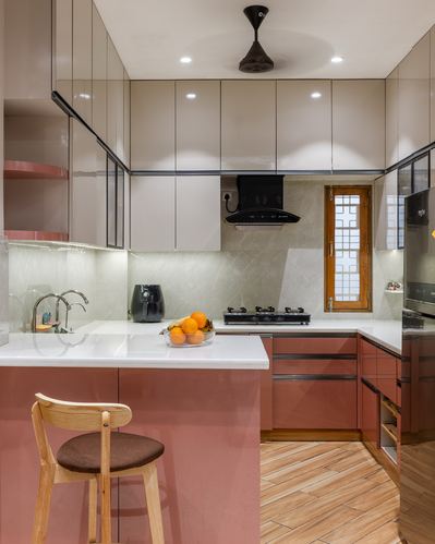 Modern L-shaped kitchen with terracotta cabinetry, white countertops, and a wooden bar stool