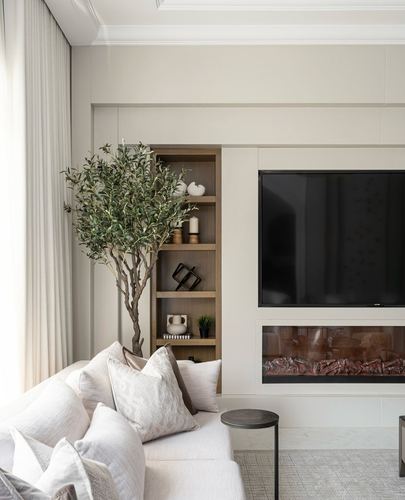 Neutral living room with tv wall, built-in shelving, faux olive tree, and linen sofa