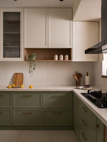 L-shaped kitchen with sage green lower cabinets, white upper cabinets, and ribbed tile backsplash