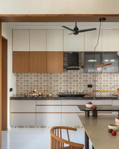 Kitchen with wood-and-white cabinetry, patterned tile backsplash, ceiling fan and dark stone counter