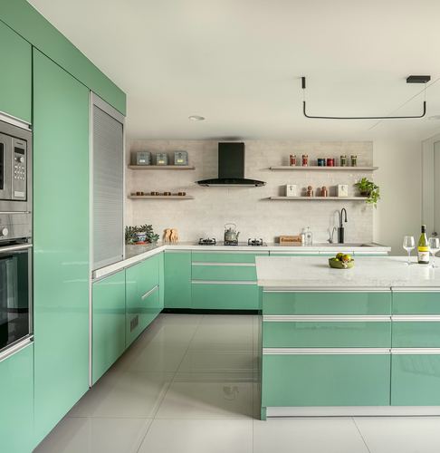 Glossy sage green kitchen with island, white stone counters, and black pendant lighting