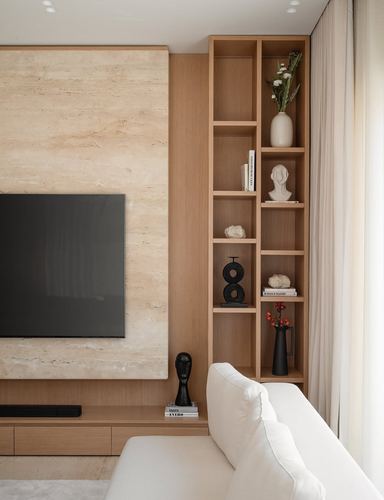 Living room with stone tv panel, wood display shelves, and white sofa