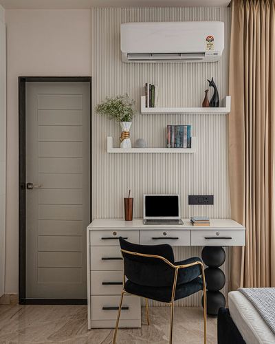 Study nook with fluted wall panel, floating shelves, white desk and black velvet chair