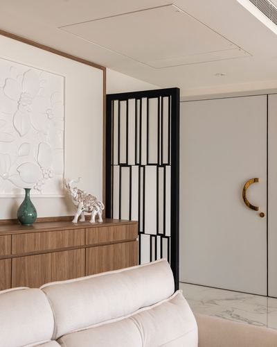 Foyer with wooden sideboard, textured floral art, black lattice screen, and marble floor near entry door