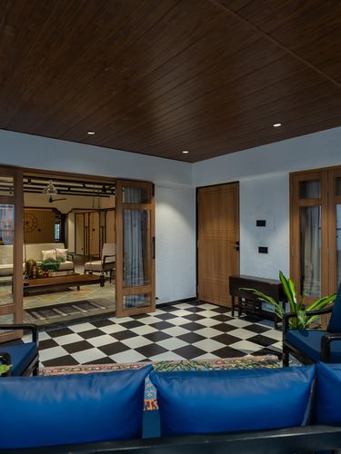 Foyer with checkerboard flooring, wood-paneled ceiling, ribbed door and blue leather bench seating