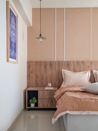 Bedroom corner with wood headboard wall, pendant light, nightstand, and framed tree artwork