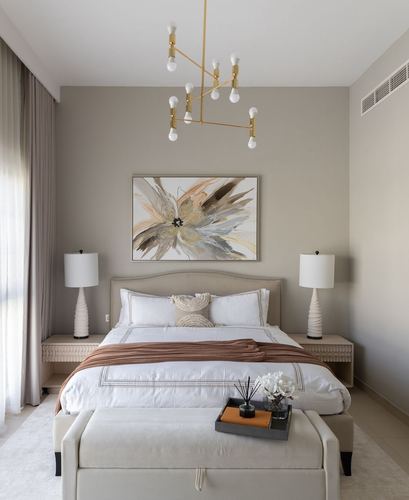 Neutral-toned bedroom with upholstered bed, abstract art, and brass chandelier over a beige palette