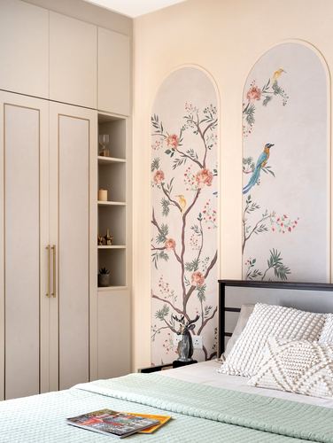 Bedroom with beige wardrobe, arched bird-and-floral mural panels, and pastel green bedding