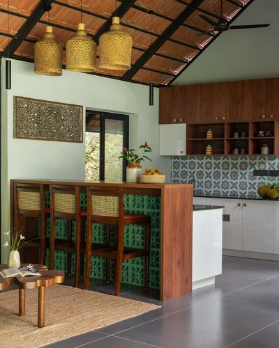 Kitchen with sloped tiled ceiling, woven pendant lights, and green breeze-block bar counter
