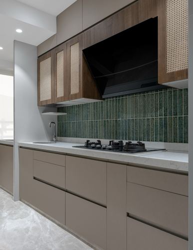 Galley kitchen with cane-front upper cabinets, black hob, and green ribbed tile backsplash