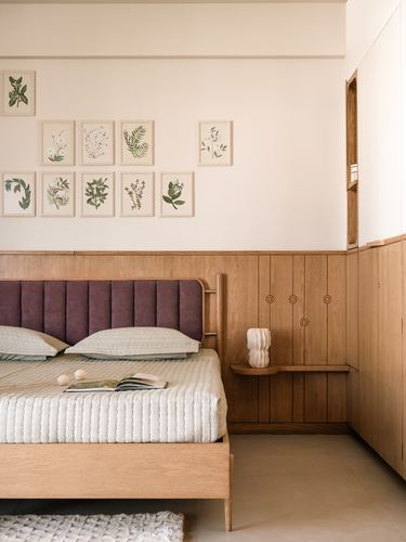 Bedroom with mauve tufted headboard, wood panelling, floating nightstand and botanical print gallery wall
