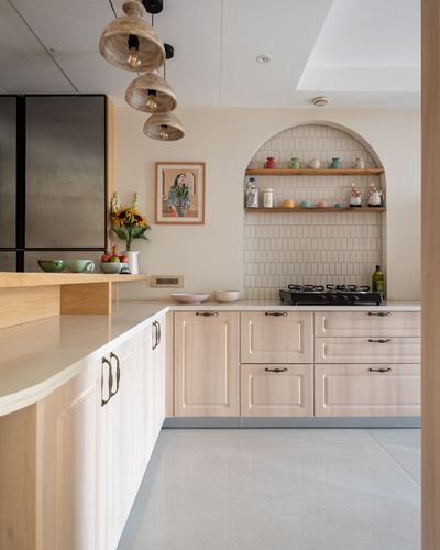 L-shaped wood kitchen with arched tiled niche shelf and woven pendant lights over island