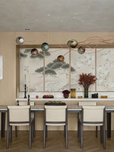 Dining room with mural wallpaper, wood-toned chairs, and floating pendant orbs on copper wires