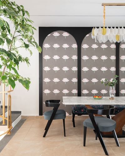 Dining area with arched patterned wall panels, marble table, and sculptural pendant light
