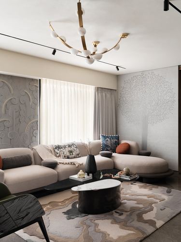 Curved beige sofa, black marble-top coffee table, patterned rug, and sculptural chandelier in a neutral living room