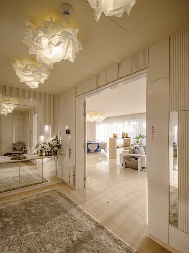 Foyer with sculptural pendant lights leading into open living and dining area beyond