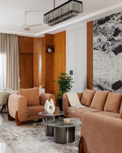 Living room with curved wood cabinetry, terracotta sofas, and marbled art panel