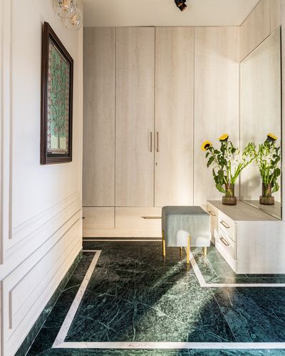 Foyer with green marble floor, wooden wardrobe, mirrored console, and sunflower bouquet
