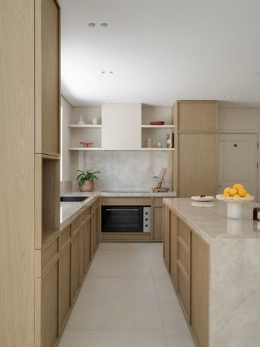 Light wood galley kitchen with marble island and open shelving, Dubai villa