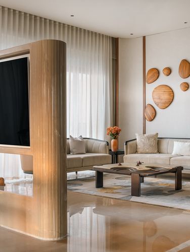 Living room with fluted curved tv column, cream sofas, and wood disc wall art