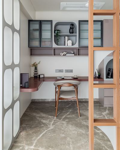 Small home study nook with mauve wall desk, fluted glass cabinets, and stone floor