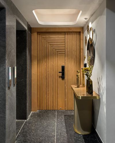 Entrance foyer with fluted wood door, stone floor, and brass-legged console table