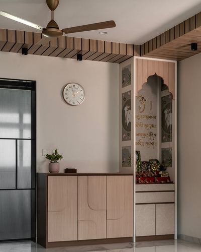 Foyer with wood cabinet, wall clock, and arched pooja niche with painted panels