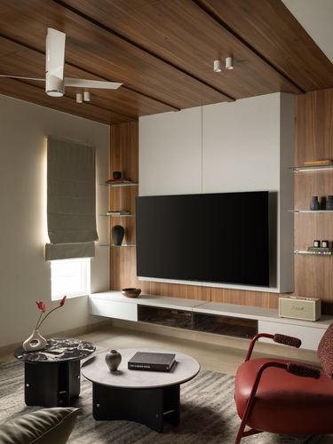Contemporary living room with wood-paneled ceiling, TV wall unit, and red leather armchair