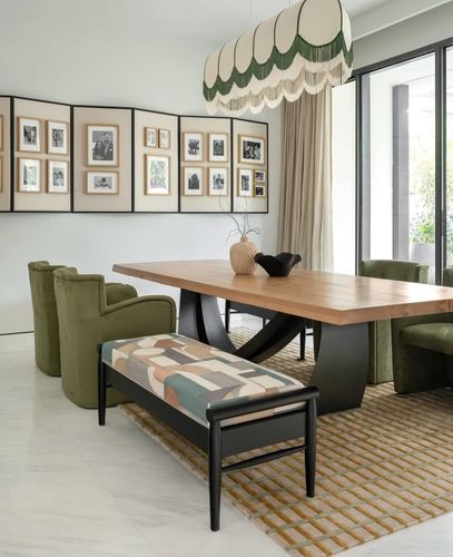 Dining room with olive velvet chairs, live-edge wood table, and gallery wall of black-and-white photographs